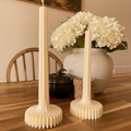 Par de velas Eterna sobre mesa de madera con hortensias blancas